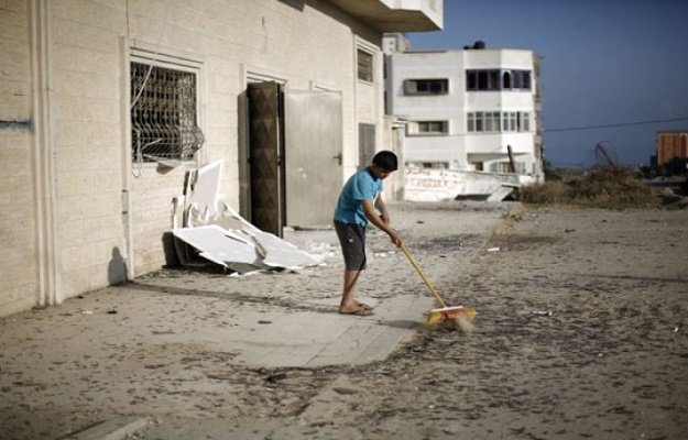a palestinian boy cleans debris near a training base of the ezzedine al qassam brigades the military wing of hamas in gaza city after israeli warplanes struck multiple militant targets in the palestinian coastal strip on june 4 2015 in response to palestinian rocket fire photo afp