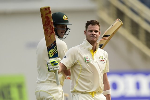 australia 039 s steve smith reacts after scoring 100 runs on the first day of the second cricket test between australia and the west indies june 11 2015 at sabina park in kingston jamaica at left is smith 039 s batting partner adam voges photo afp