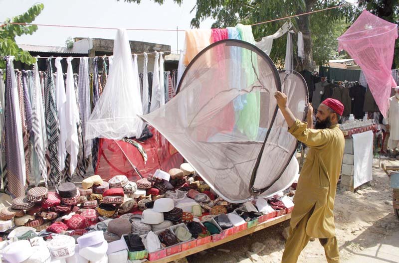 a man displays mosquito netting for sale at his roadside set up in islamabad photo inp