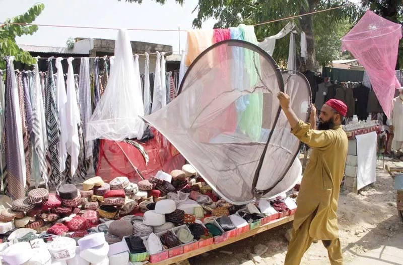 a man displays mosquito netting for sale at his roadside set up in islamabad photo inp a man displays mosquito netting for sale at his roadside set up in islamabad photo inp
