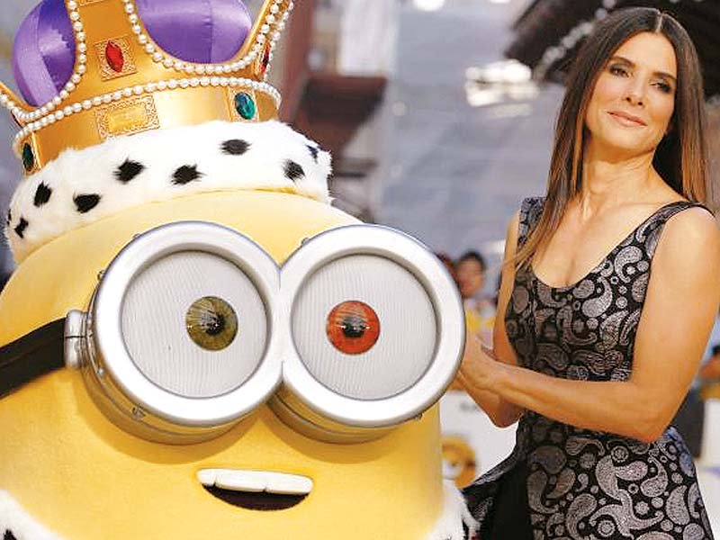 actor sandra bullock poses with a character in costume from the film during the minions world premiere photo file