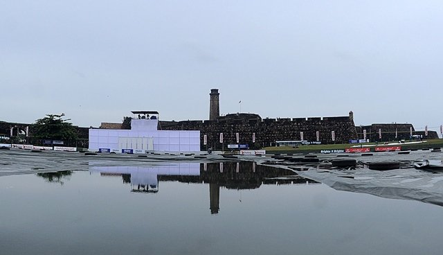 the galle fort is reflected in water lying on plastic sheeting over the playing surface after rain showers delayed play during the first day of the opening test match between sri lanka and pakistan at the galle international cricket stadium in galle on june 17 2015 photo afp