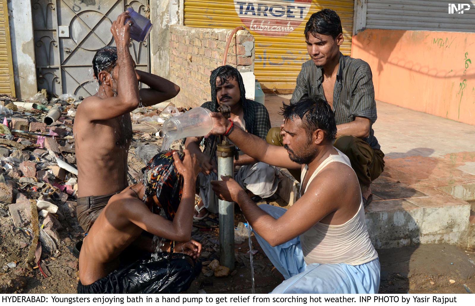 men bathe from a public tap in hyderabad on saturday to beat the heat photo inp