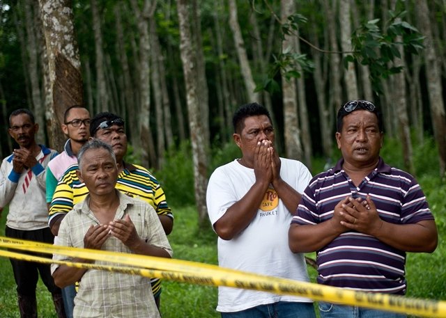 malaysian villagers offer prayers during the re burial of remains believed to be those of ethnic rohingya found at human trafficking camps in the country 039 s north at kampung tualang some 16kms east of alor setar photo afp