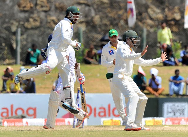 pakistan wicketkeeper sarfraz ahmed l and azhar ali r celebrate the dismissal of sri lankan cricketer dimuth karunaratne during the final day of the opening test match between sri lanka and pakistan at the galle international cricket stadium in galle on june 21 2015 photo afp