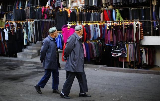 two ethnic uighur men walk in a clothing market in downtown urumqi xinjiang province photo reuters