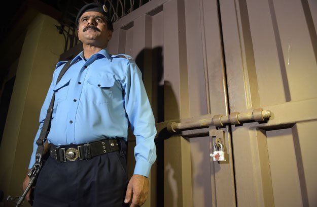 a policeman stands guard outside the office of the international charity save the children sealed by order of authorities in islamabad on june 11 2015 photo afp