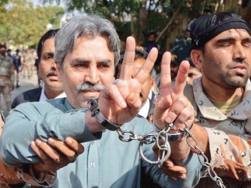 mqm leader amir khan poses in handcuffs as he was escorted back to the vehicle by rangers personnel after being presented before an anti terrorism court he has been accused of instigating terrorism and harbouring criminals photo file