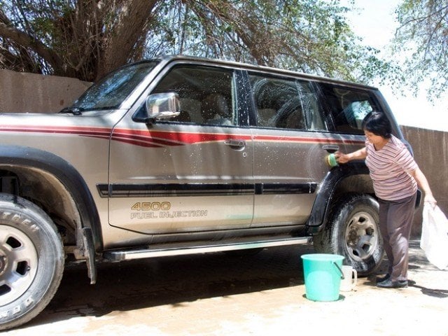 a domestic worker washes a car in front of her employers 039 house in kuwait photo reuters