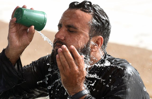 a muslim man cools down with water at a mosque during a heatwave in karachi on june 22 2015 photo afp