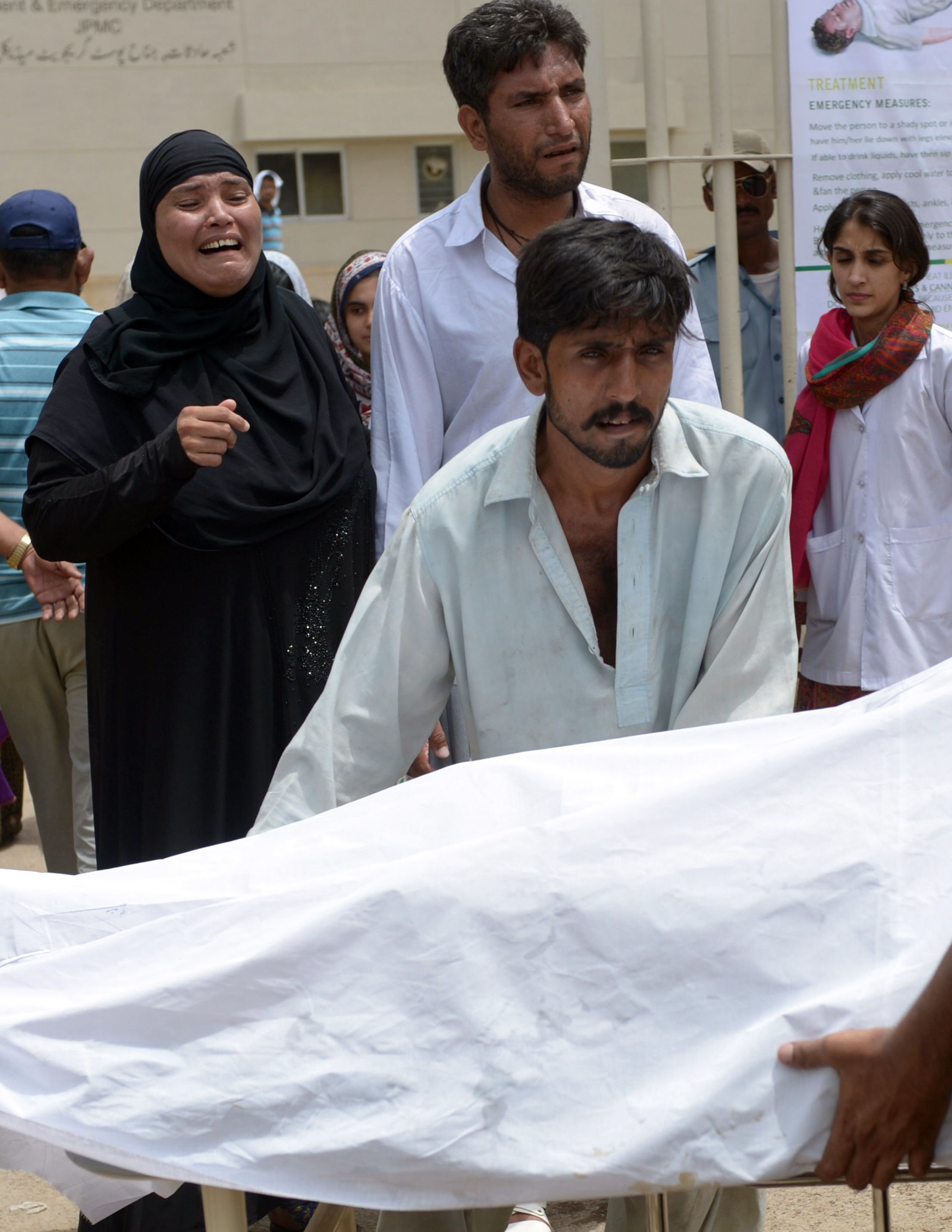 relatives mourn the death of a heatstroke victim outside a hospital in karachi photo afp