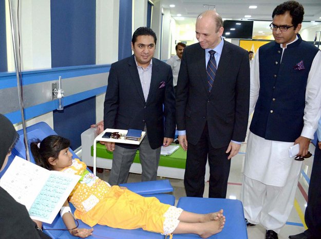 ambassador of belgium h e mr peter claes accompanied by md pakistan bait ul mal barrister abid waheed inquiring about health of thalassaemic child patient during their visit to pakistan thalassaemia centre photo nni