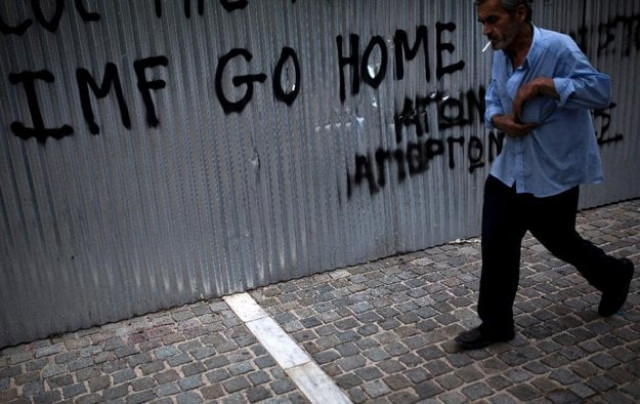 a man walks in front of graffiti reading 039 039 imf go home 039 039 in athens photo afp a man walks in front of graffiti reading 039 039 imf go home 039 039 in athens photo afp