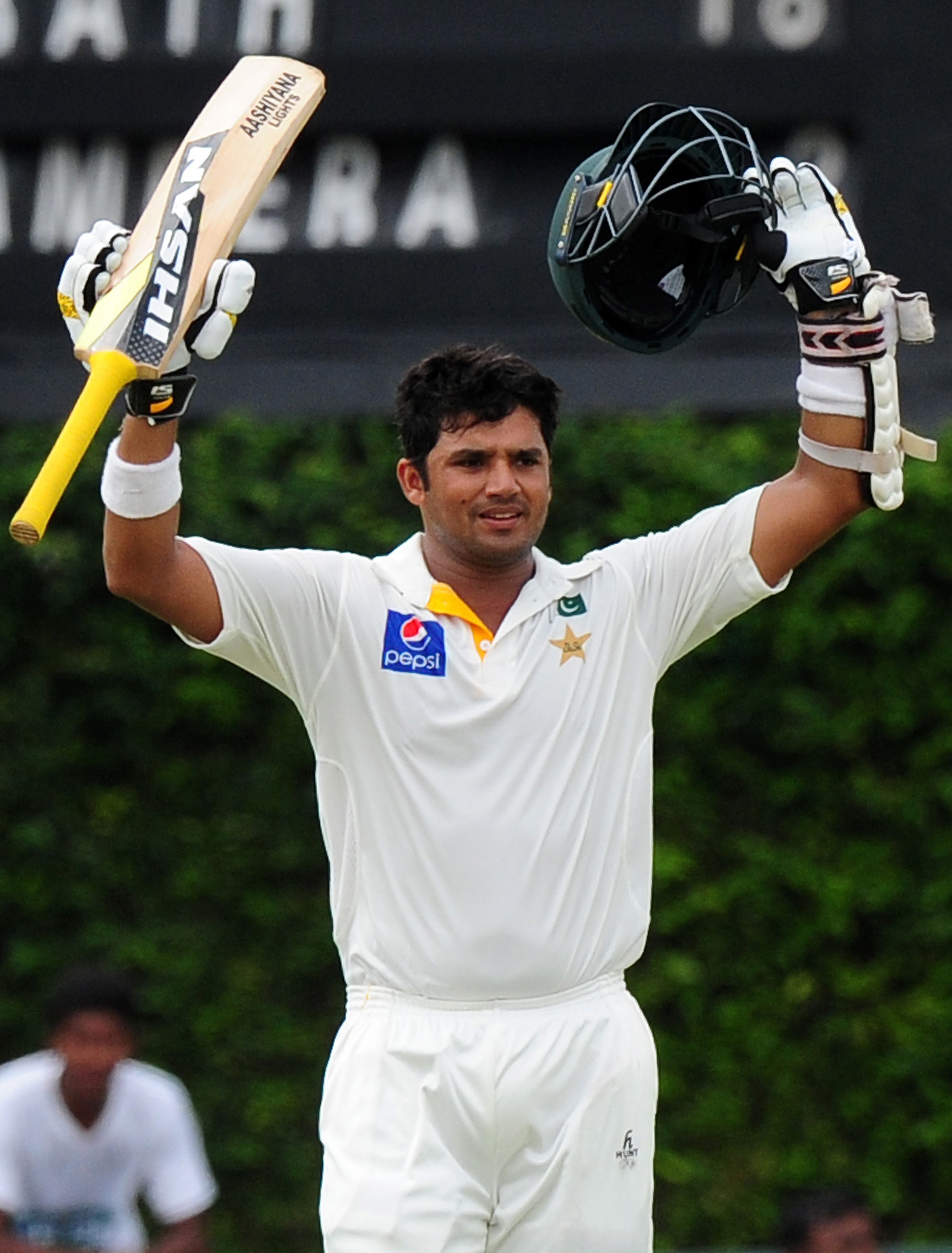 azhar ali raises his bat and helmet in celebration after scoring a century during the fourth day of the second test match between sri lanka and pakistan photo afp