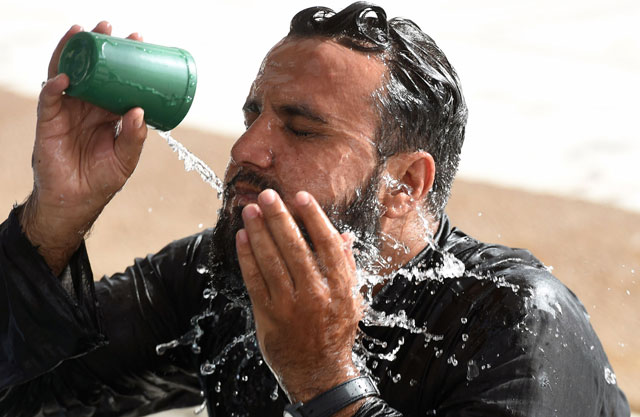 a man cools down with water at a mosque during a heatwave in karachi on june 22 2015 photo afp