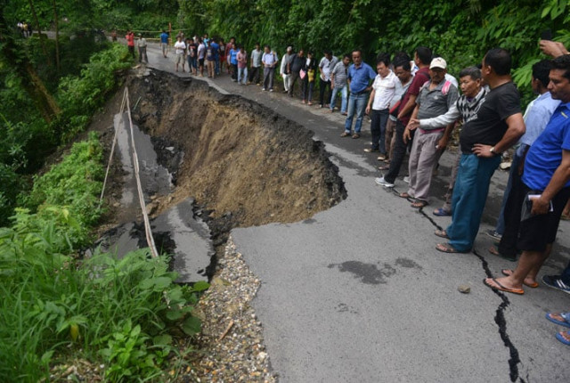 indian bystanders walk on a landslide affected roadway in the village of gayabari on july 2 2015 after landslides struck the eastern state of west bengal photo afp indian bystanders walk on a landslide affected roadway in the village of gayabari on july 2 2015 after landslides struck the eastern state of west bengal photo afp