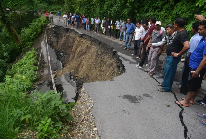 indian bystanders walk on a landslide affected roadway in the village of gayabari on july 2 2015 after landslides struck the eastern state of west bengal photo afp indian bystanders walk on a landslide affected roadway in the village of gayabari on july 2 2015 after landslides struck the eastern state of west bengal photo afp