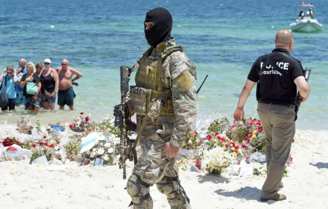 a tunisian special force officer and a policeman patrol the beach as tourists take part in a ceremony on july 3 2015 in memory of those killed the previous week by a jihadist gunman in the popular resort of port el kantaoui photo afp a tunisian special force officer and a policeman patrol the beach as tourists take part in a ceremony on july 3 2015 in memory of those killed the previous week by a jihadist gunman in the popular resort of port el kantaoui photo afp