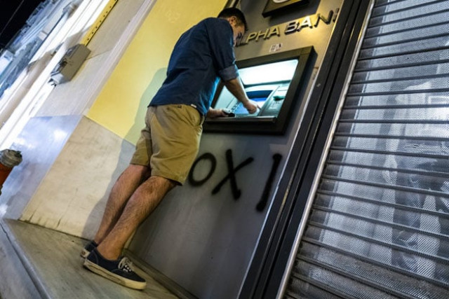 a man withdraws money from an atm in downtown athens photo afp a man withdraws money from an atm in downtown athens photo afp