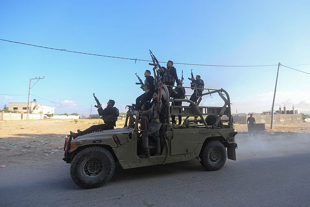 Palestinian militants ride an Israeli military vehicle that was seized by gunmen who infiltrated areas of southern Israel, in the northern Gaza Strip October 7. REUTERS