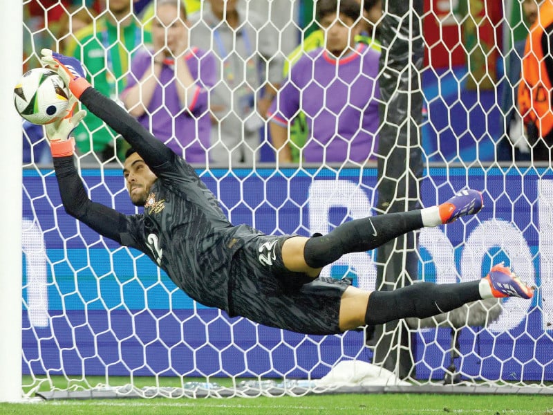diogo costa saves a penalty from slovenia s jure balkovec unseen during portugal s penalty shoot out win at euro 2024 photo afp