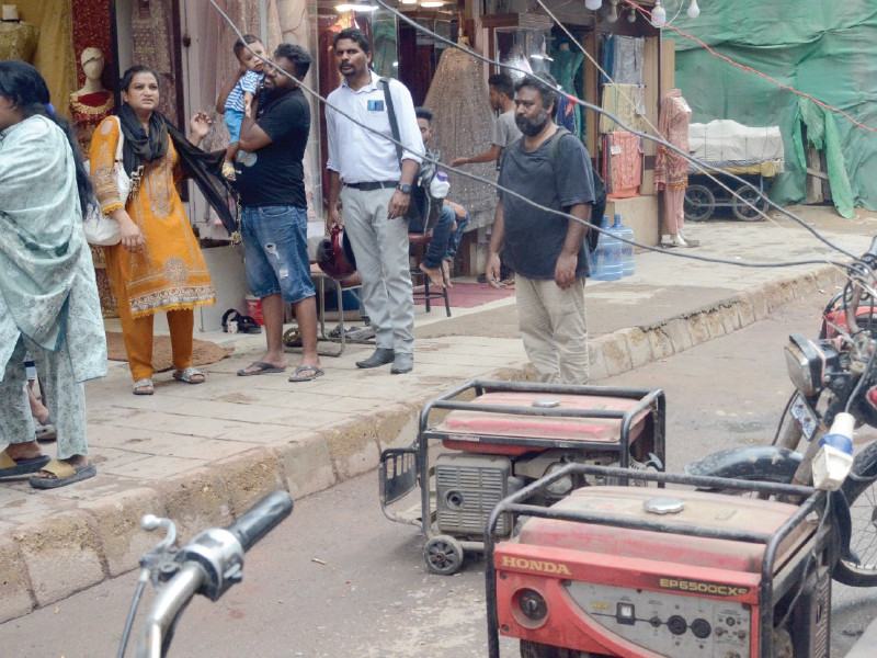 shopkeepers have put generators on a street during an electricity breakdown in the jama cloth market area on tuesday the cables carrying 220 volts coiling over a bike and passing above the heads of pedestrians in a precarious manner amid sporadic light rain pose a serious threat to life and property photo jalal qureshi express