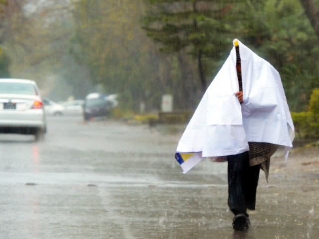 a man wraps himself with plastic sheeting as he walks during rain in islamabad photo afp a man wraps himself with plastic sheeting as he walks during rain in islamabad photo afp