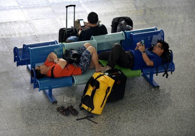 passengers rest in the international terminal at bali 039 s ngurah rai airport in denpasar waiting for information of flight delays due to volcanic ash near indonesia 039 s resort island photo afp