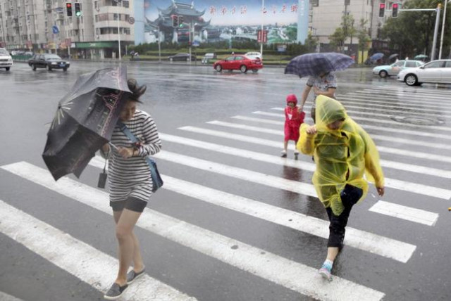 pedestrians hold their umbrellas against strong wind as typhoon chan hom hits shanghai china july 11 2015 photo reuters pedestrians hold their umbrellas against strong wind as typhoon chan hom hits shanghai china july 11 2015 photo reuters