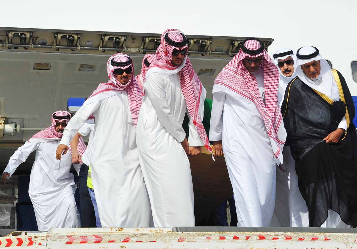 saudi prince turki al faisal r stands next to the coffin of prince saud al faisal as it is being unloaded from a plane upon its arrival in jeddah on july 11 photo afp