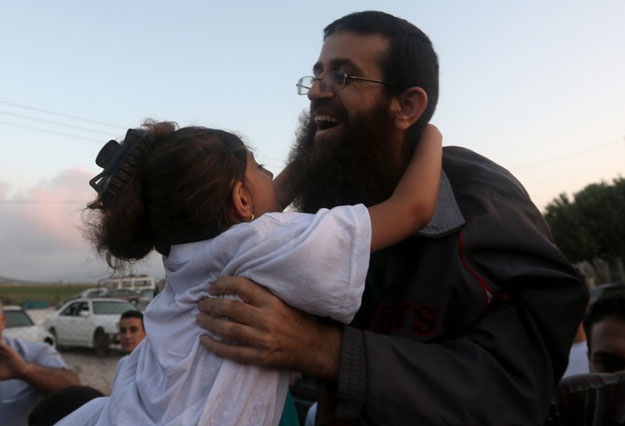 khader adnan a palestinian prisoner who staged a 56 day hunger strike while being detained for a year without charge by israeli authorities hugs a relative as he arrives in the west bank village of arraba after his release early on july 12 2015 photo afp