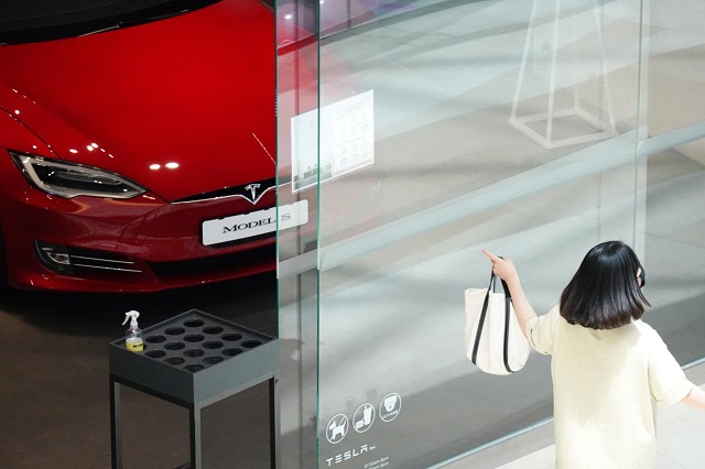 a woman walks past a tesla dealership in hanam south korea july 6 2020 photo reuters