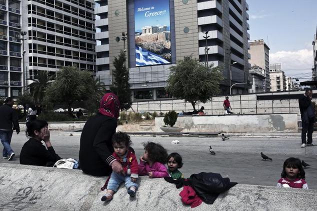 syrian migrants who arrived in greece by its sea borders sit on omonia square in athens on april 25 2015 photo afp