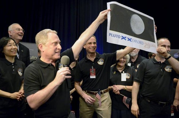 nasa principal investigator for new horizons mission alan stern l and co investigator will grundy r hold up an enlarged out dated u s postage stamp with the quot not yet quot crossed out during the celebration of the spacecraft new horizons flyby of pluto at nasa 039 s johns hopkins applied physics laboratory in laurel maryland july 14 2015 photo reuters