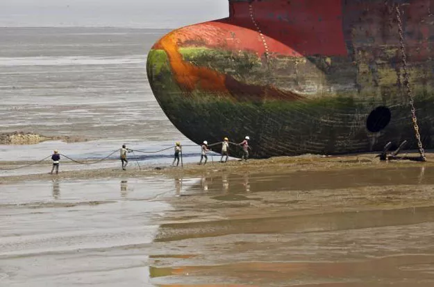 workers carry a rope line to fasten a decommissioned ship at the alang shipyard in gujarat india on march 27 2015 photo reuters workers carry a rope line to fasten a decommissioned ship at the alang shipyard in gujarat india on march 27 2015 photo reuters