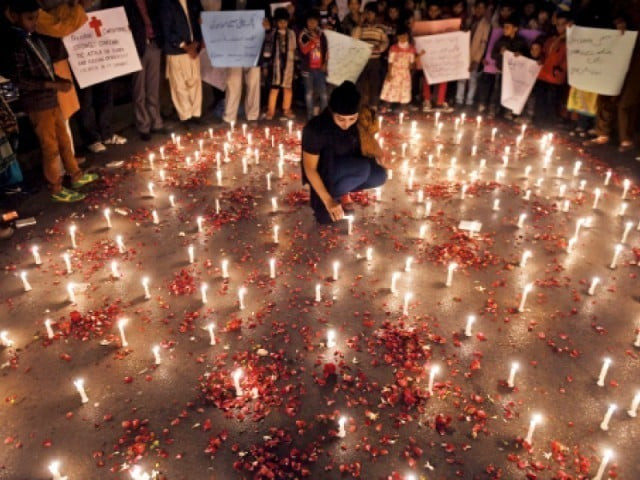 a girl lights candles for the peshawar victims photo afp a girl lights candles for the peshawar victims photo afp