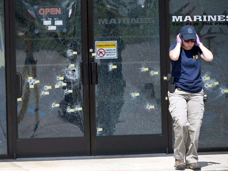 an fbi officer walks away from the bullet riddled doors at the armed forces career centre in chattanooga tennessee photo afp