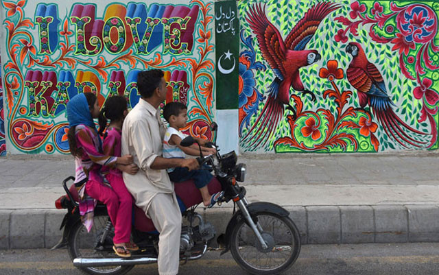 a pakistani family looks at art work on a wall on a commercial street in the southern port city of karachi photo afp a pakistani family looks at art work on a wall on a commercial street in the southern port city of karachi photo afp