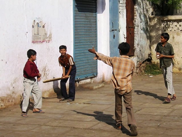 kids play cricket in a street in karachi photo file