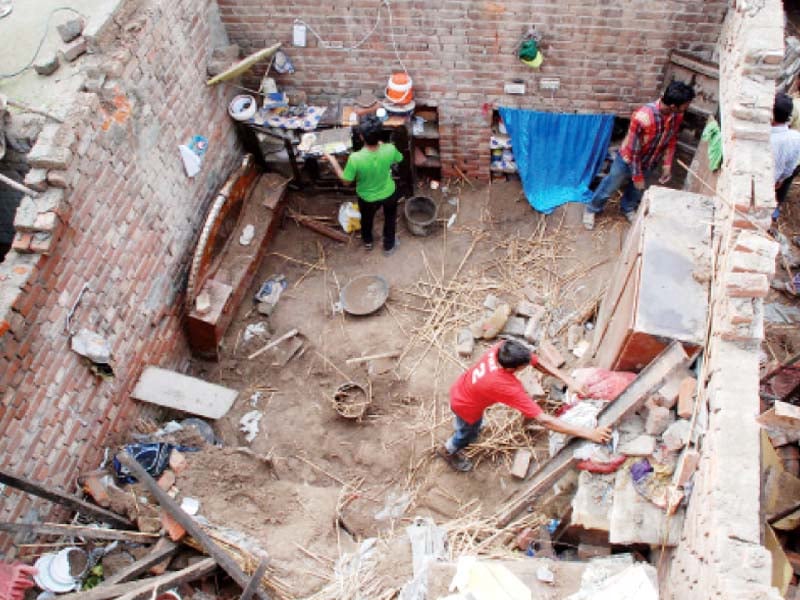 two boys salvage valuables after the roof collapse photo riaz ahmed express