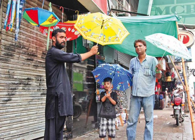 ali haider buys an umbrella in zainab market while his excited son looks on despite the frequent power outages and flooded streets several residents made the most of the pleasant weather on sunday photo aysha saleem express ali haider buys an umbrella in zainab market while his excited son looks on despite the frequent power outages and flooded streets several residents made the most of the pleasant weather on sunday photo aysha saleem express