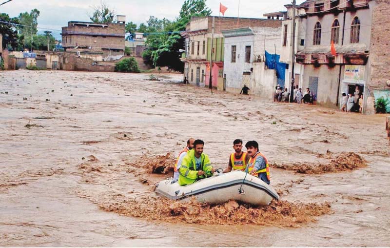 rescuers in an inflatable boat patrol a neighbourhood in peshawar photo inp