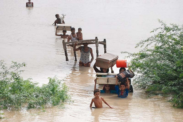 people wade through water carrying their essentials as a high flood passes through the barrages of sindh photo naeem ahmed ghouri express people wade through water carrying their essentials as a high flood passes through the barrages of sindh photo naeem ahmed ghouri express