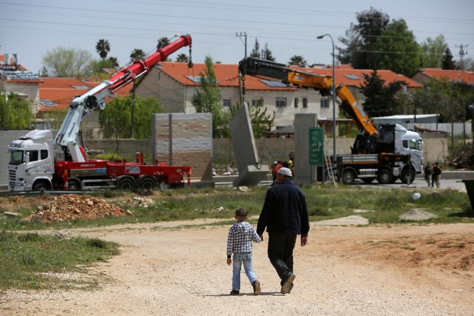 palestinians walking near the israeli settlement of beit el in the occupied west bank on april 7 2015 photo afp