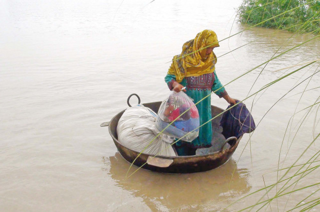 a woman uses a cauldron to reach dry land in a flood hit area of sukkur photo ppi a woman uses a cauldron to reach dry land in a flood hit area of sukkur photo ppi
