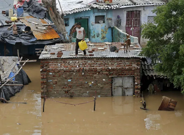 a boy holds a container as he stands atop a submerged hut situated in the flooded banks of river sabarmati after heavy monsoon rains in the western india caused the rise in water levels in ahmedabad india july 30 2015 photo reuters a boy holds a container as he stands atop a submerged hut situated in the flooded banks of river sabarmati after heavy monsoon rains in the western india caused the rise in water levels in ahmedabad india july 30 2015 photo reuters