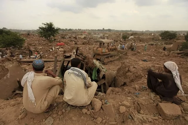 residents watch as officials use a bulldozer to demolish illegal houses at a slum on the outskirts of islamabad photo reuters residents watch as officials use a bulldozer to demolish illegal houses at a slum on the outskirts of islamabad photo reuters