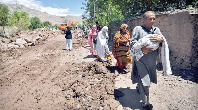 a family crosses a damaged flood road photo inp a family crosses a damaged flood road photo inp