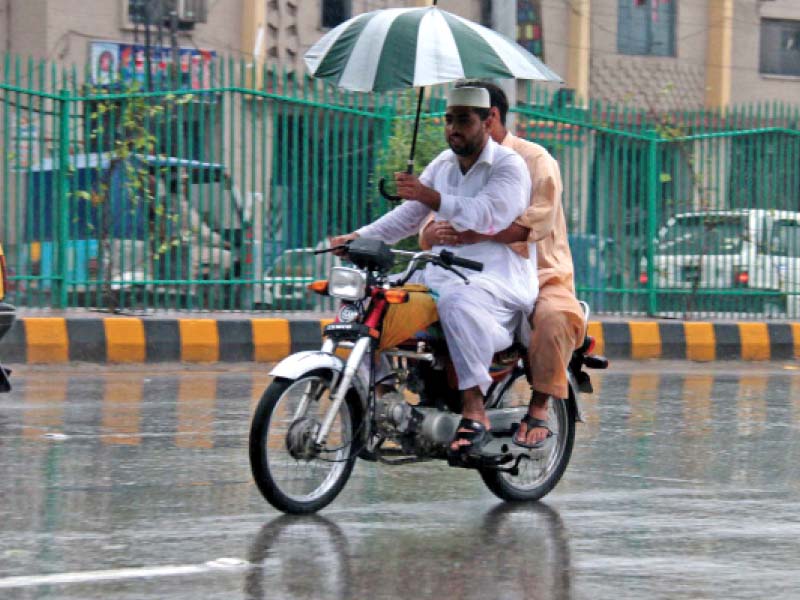 men ride a motorcycle during rain in city photo muhammad iqbal express