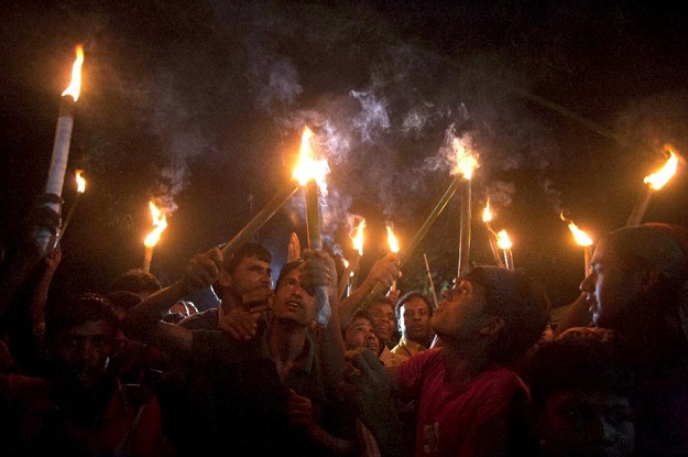 former indian enclave residents carry lit torches during a procession at dasiarchhara kurigram in bangladesh on august 1 2015 photo afp
